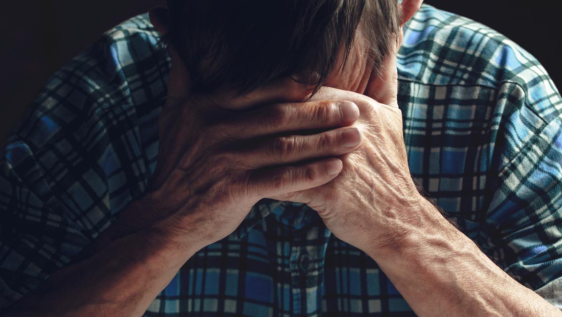 a man holds his head in his hands