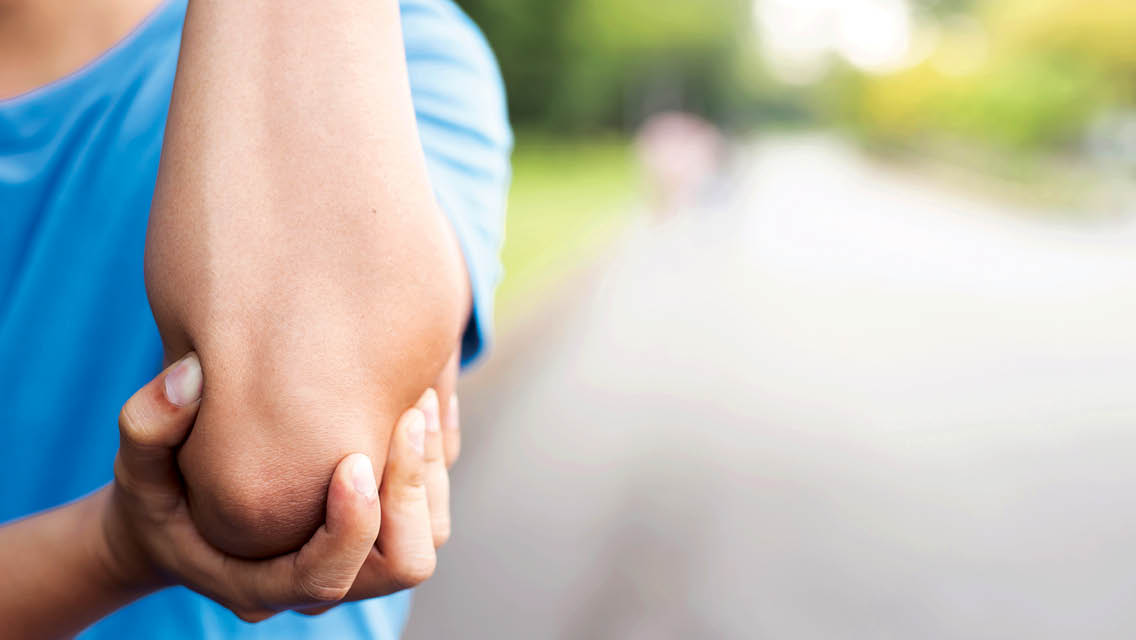 a person holds their elbow