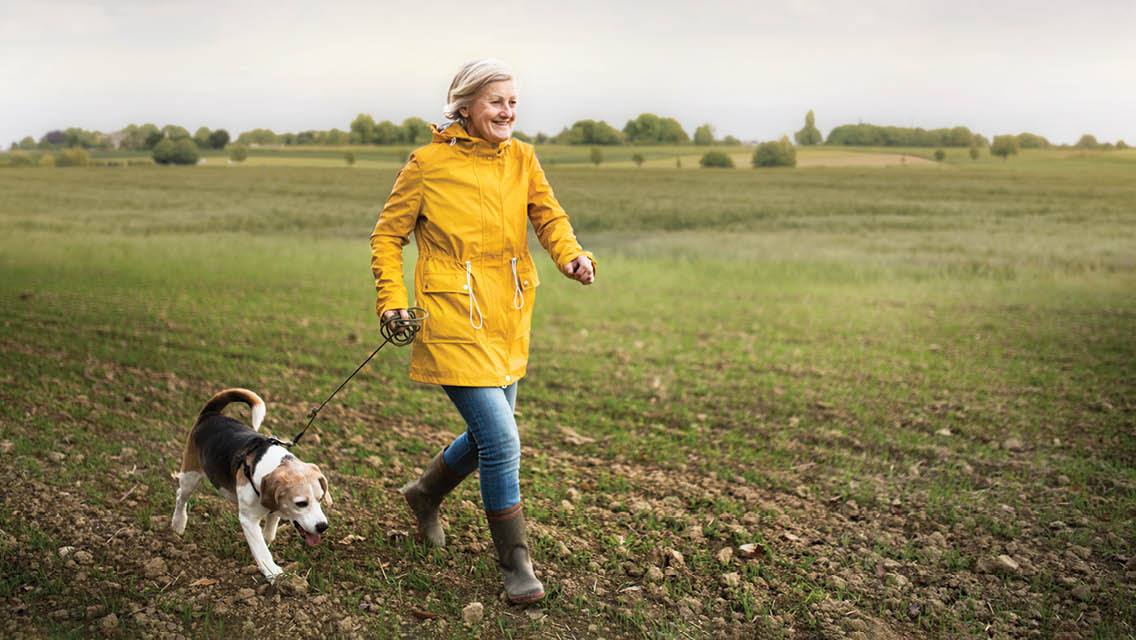 a woman slowly runs with her older dog
