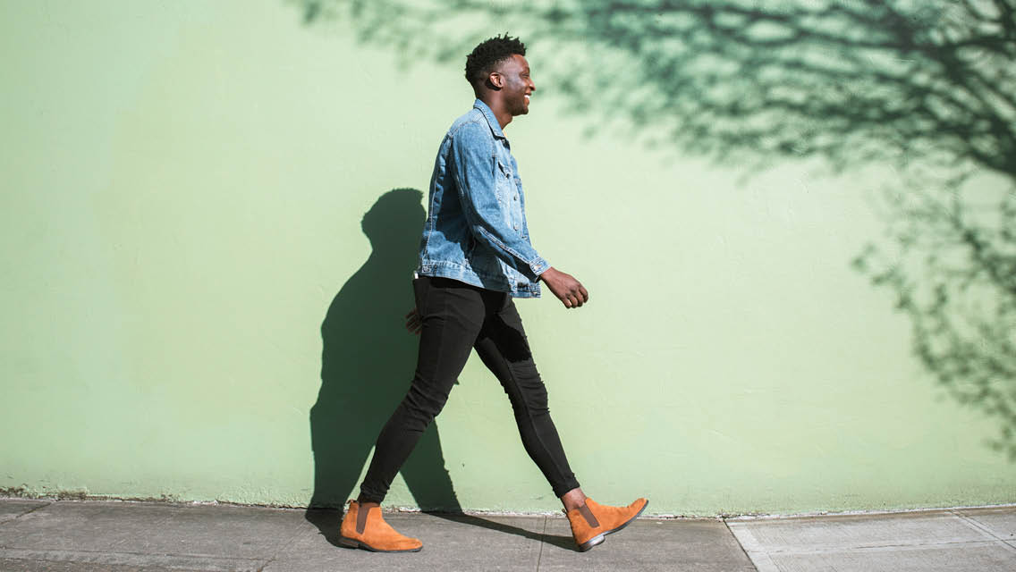 a man walks by a colorful wall