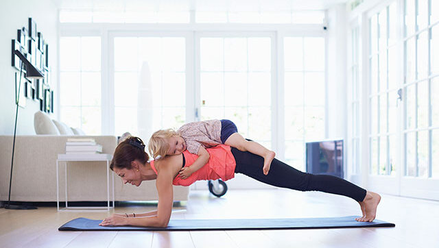 woman holding plank with child on her back
