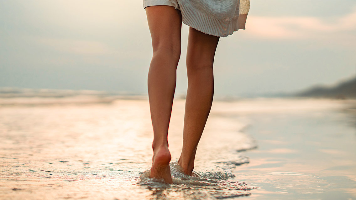 Woman walking along beach