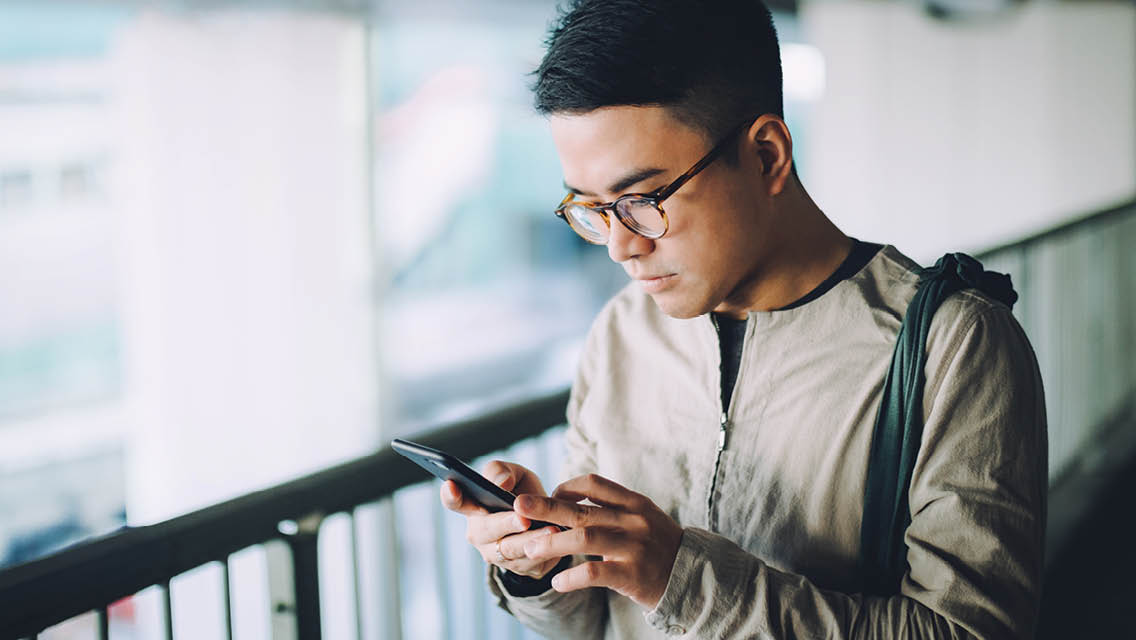 a young man looks at his phone