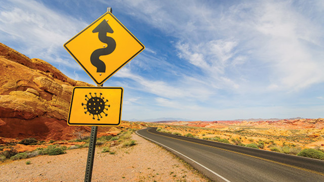A road sign showing the COVID virus