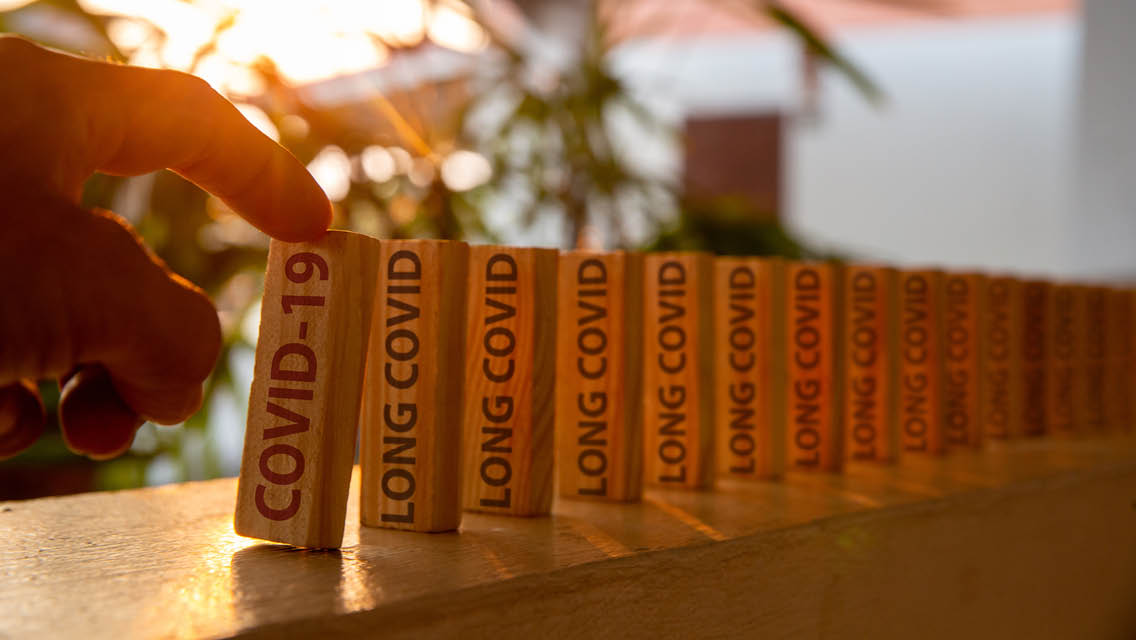 dominos set up with the words long covid written on them