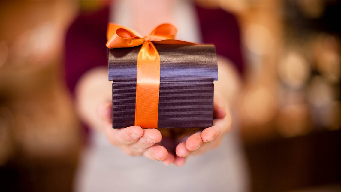 a person holds a small, wrapped gift
