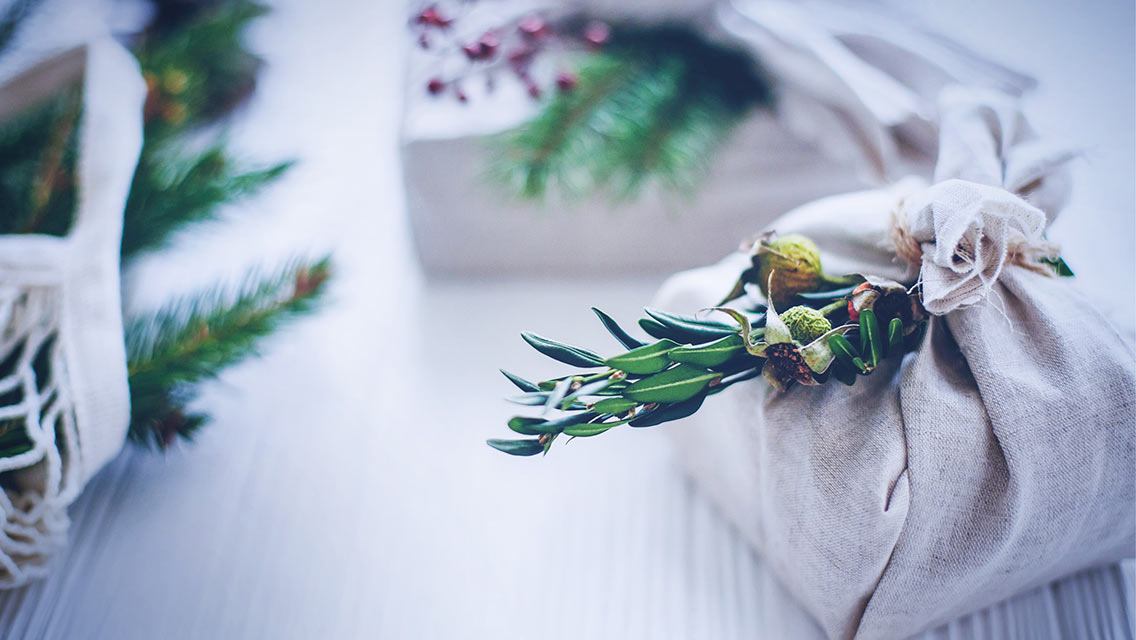 gifts wrapped in cloth with a sprig of greens