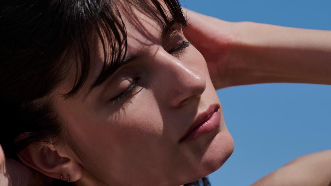 Person with eyes closed and face turned to the sun