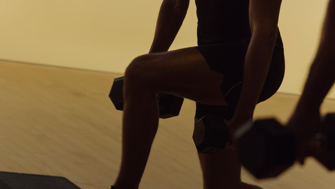 person holding weights during a split squat