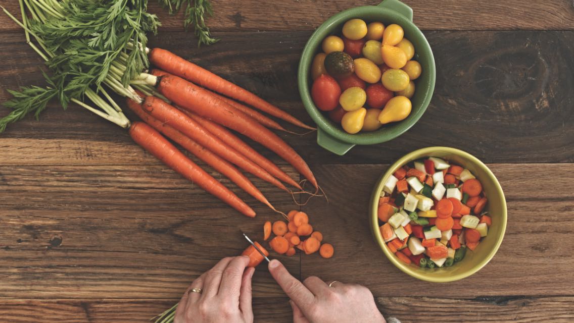Person chopping up fresh vegetables.