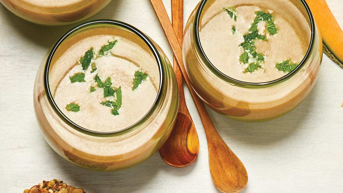 Three bowls of chilled cucumber and cantaloupe blender soup.