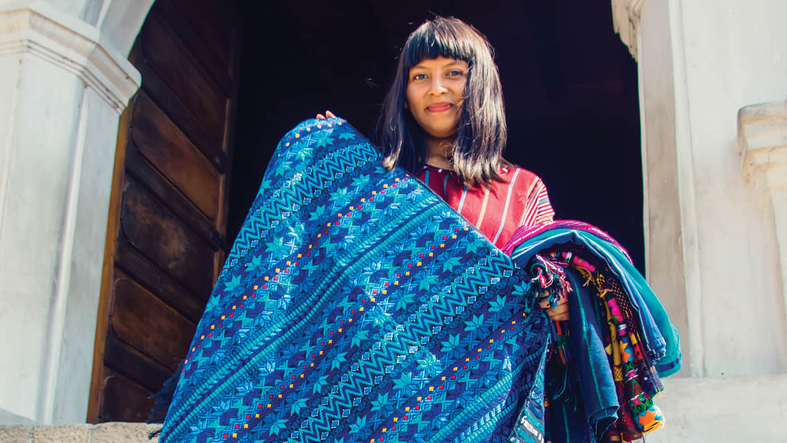 a woman holds a gorgeous handwoven blanket