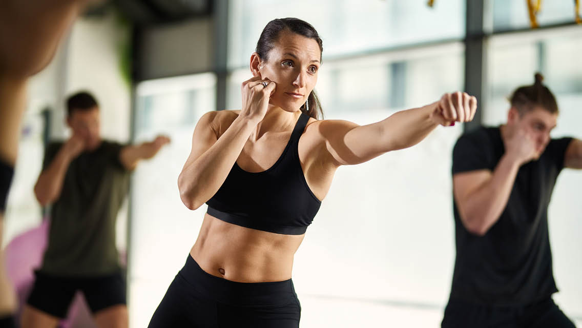 a woman throws a punch in a kickboxing class