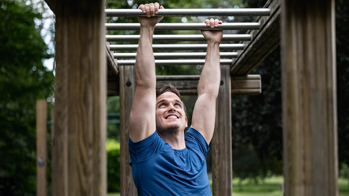 a man traverses the monkey bars