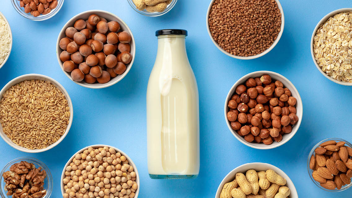 bowls of various nuts around a quart of milk