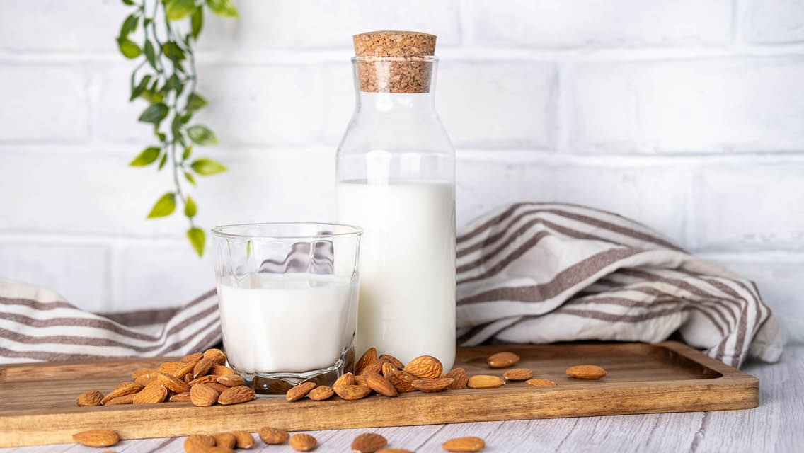 milk bottle with almonds surrounding it