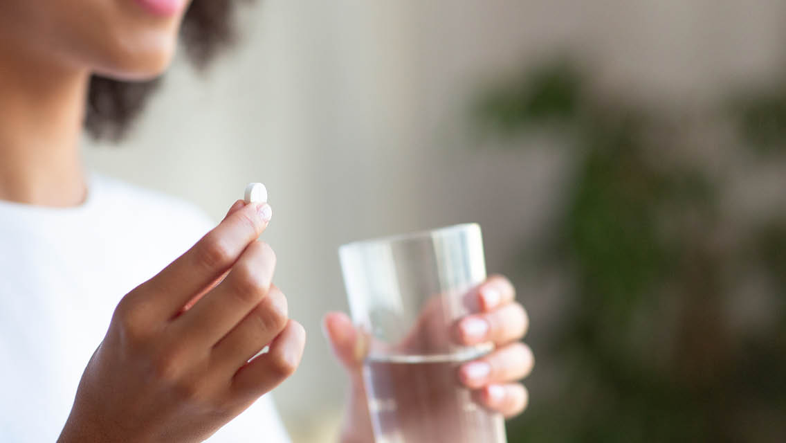 a woman takes a melatonin supplement