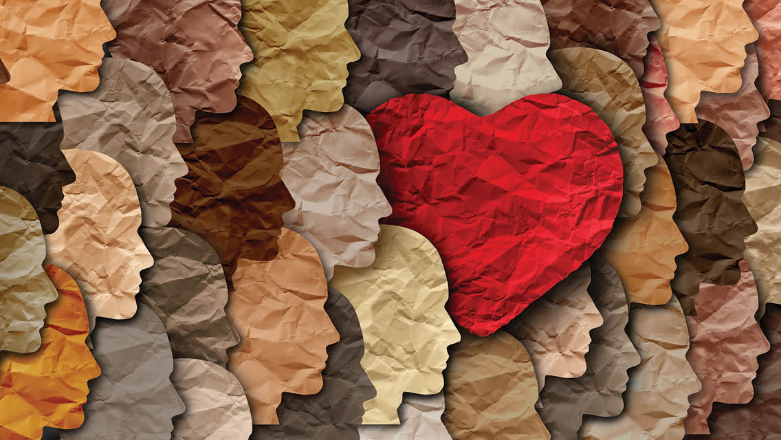 various shades of brown and tan faces cut out of paper with a red heart.