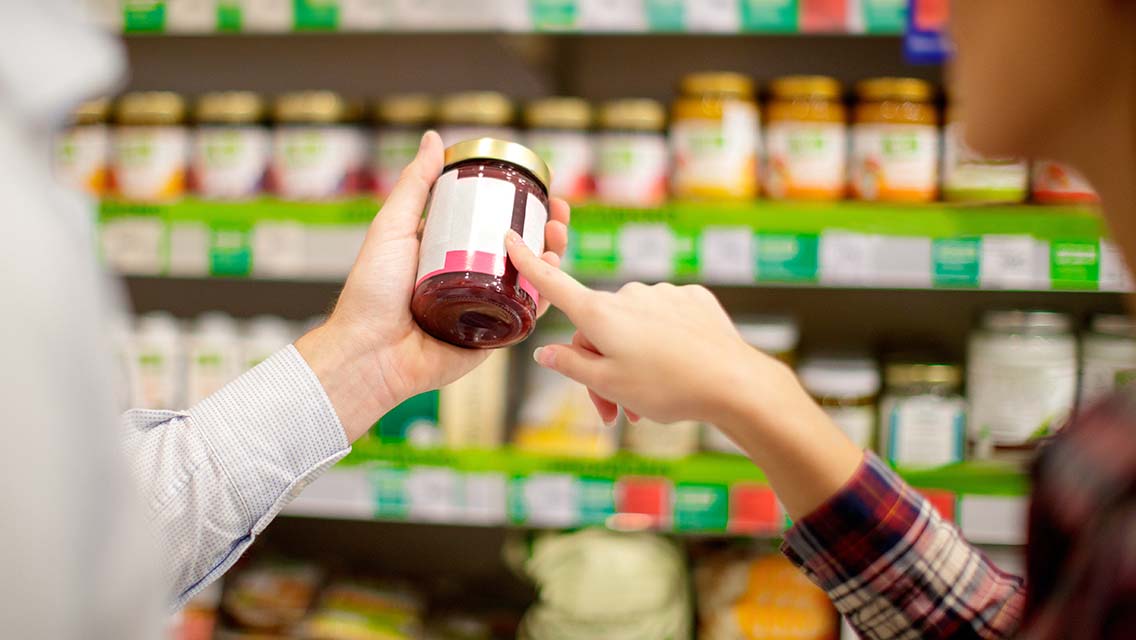 people look at a label on a jar of jelly