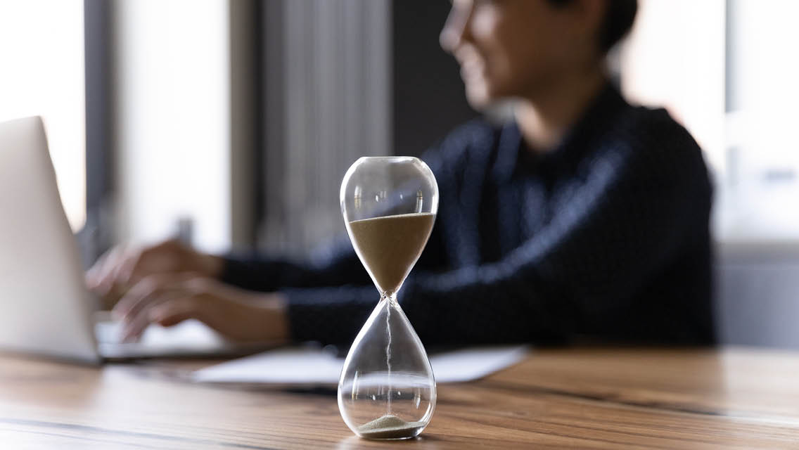 a sands of time hour glass empties while a person works
