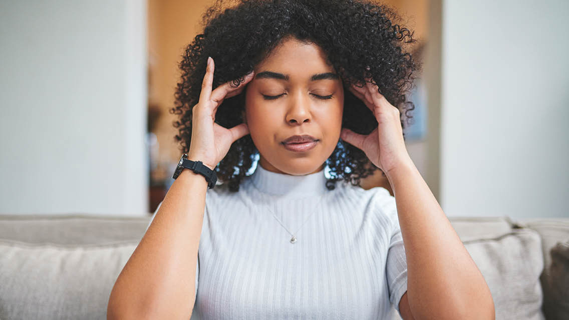 a woman holds her head while meditating