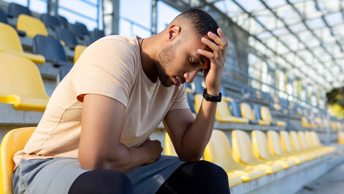 a man holds his head feeling detejected