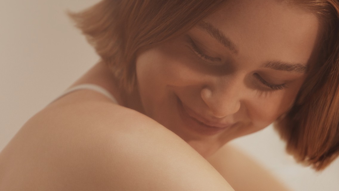 A woman smiling looking over her shoulder.