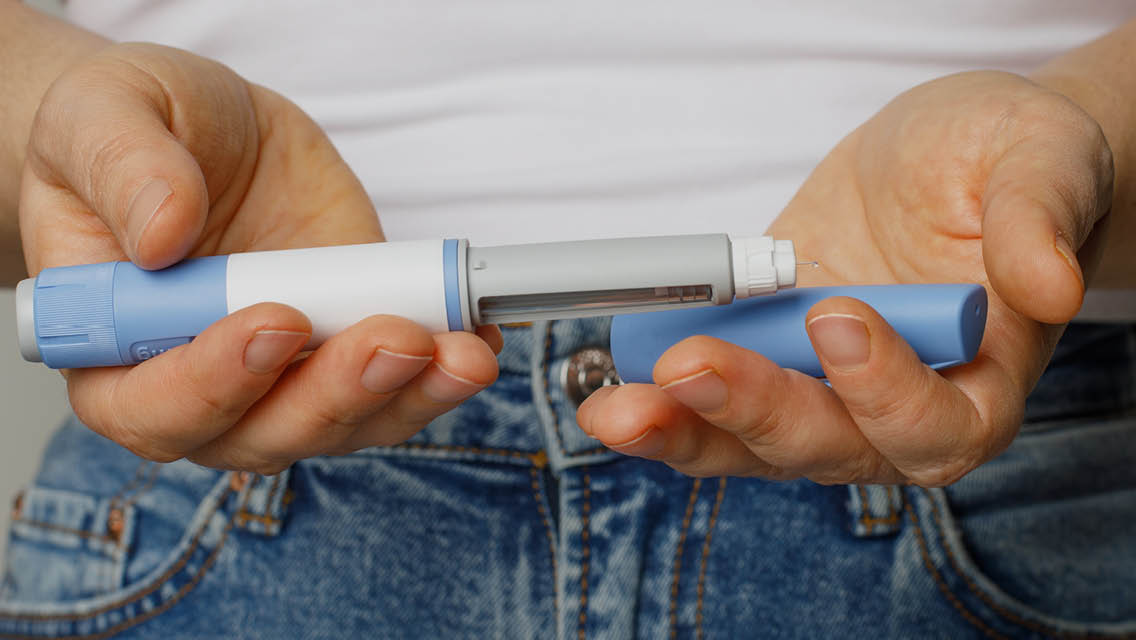 a person holds a GLP injector