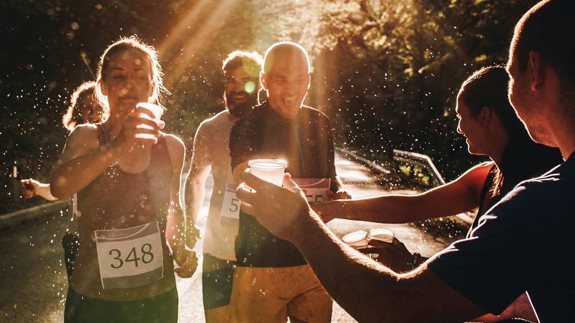 runners pick up their drinks during a race