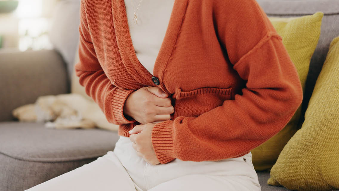 a woman holds her gut with clenched fists
