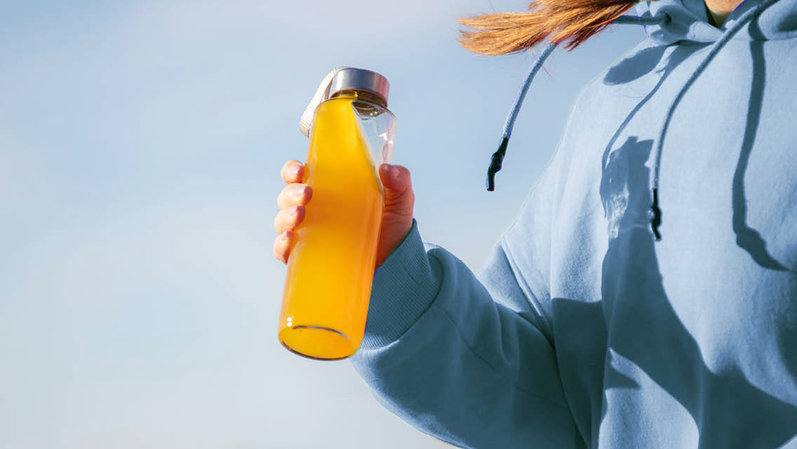 a woman prepares to drink an electrolyte beverage