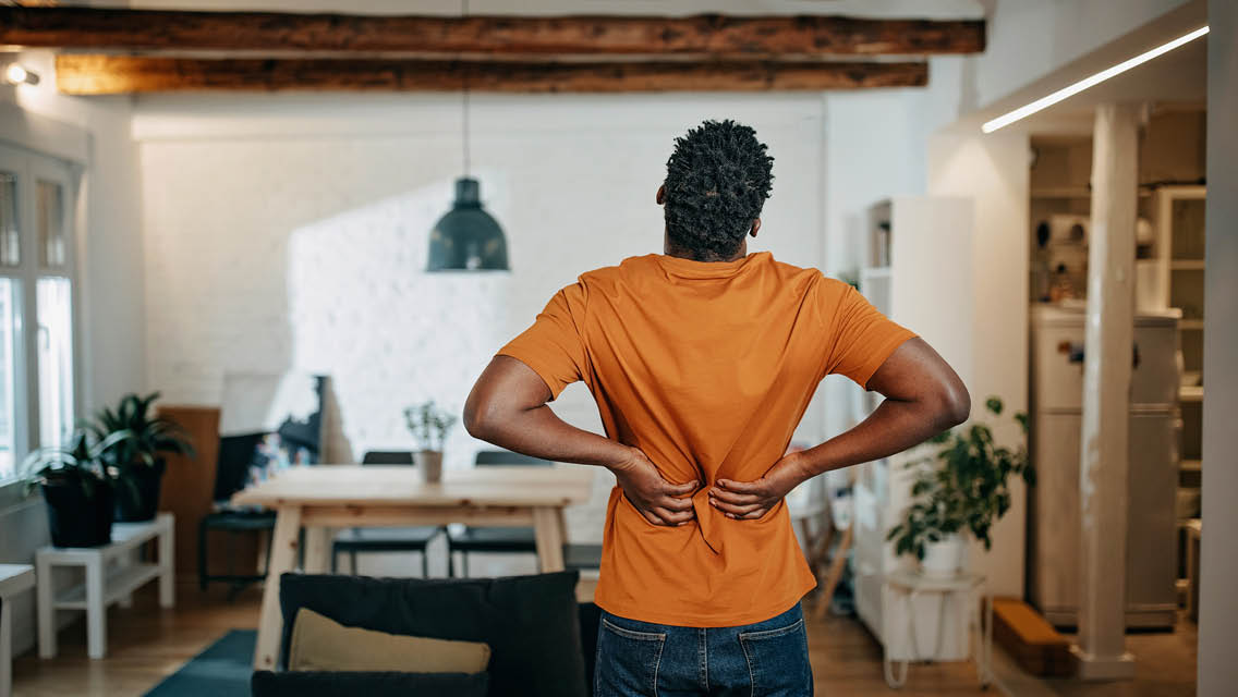 a man holds his back