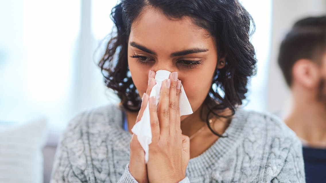 a woman blows her nose