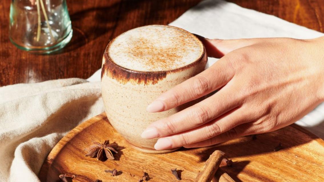 hand holding mug of pumpkin spice latter