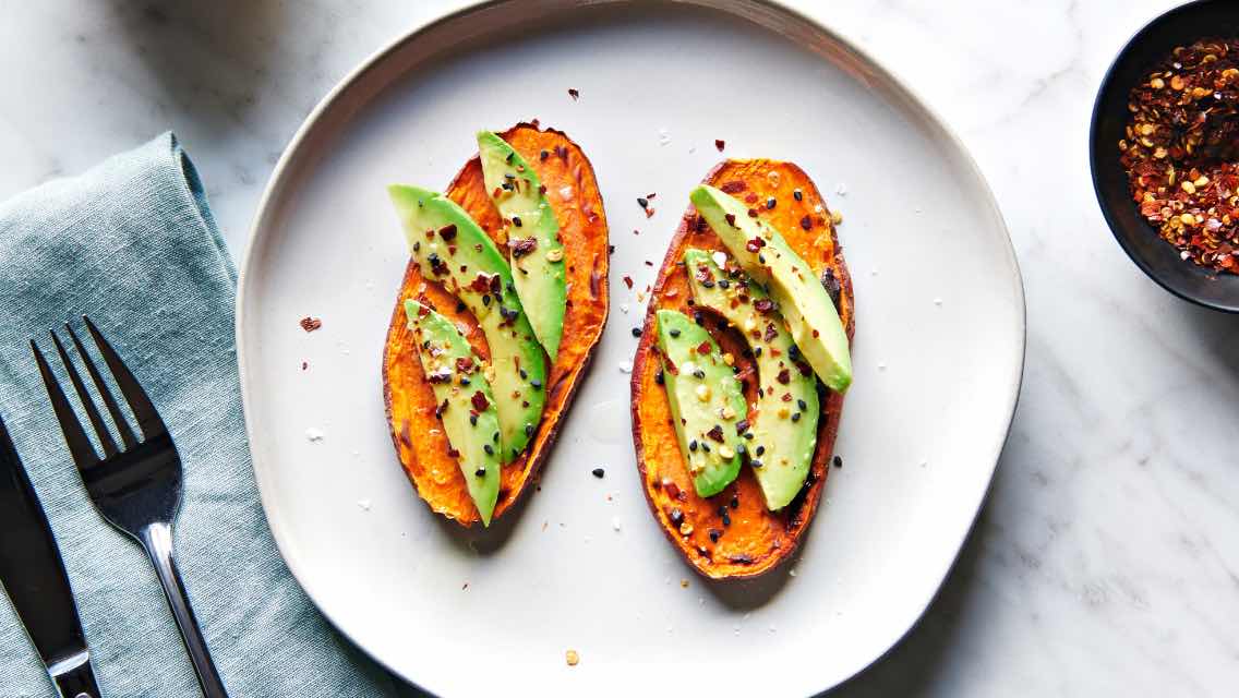Two slices of avocado sweet potato toast on a plate.