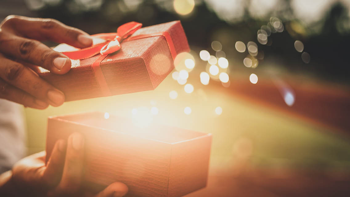 a person opens a box with a bright light shining out.