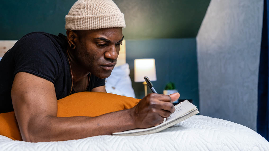 a man writes in a journal