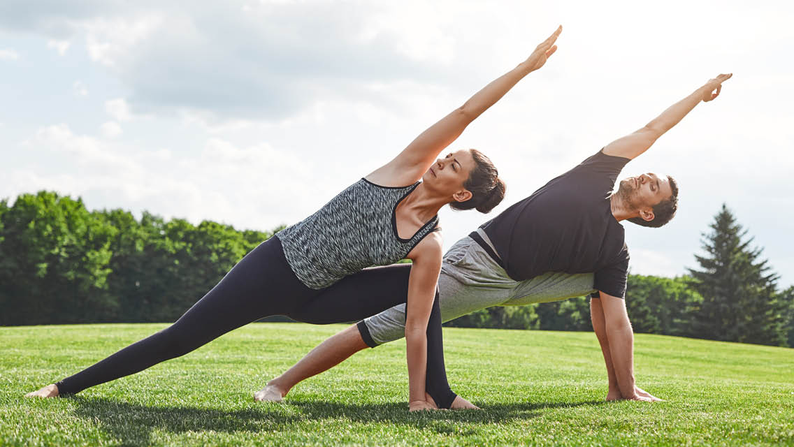 two people do yoga outside