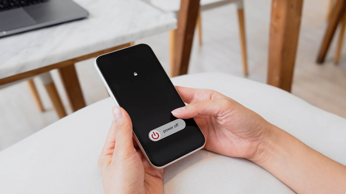 a person turning off their cell phone