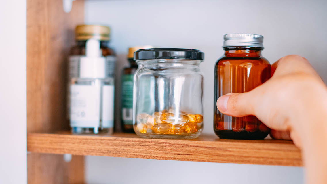 a person stocks a medicine cabinet