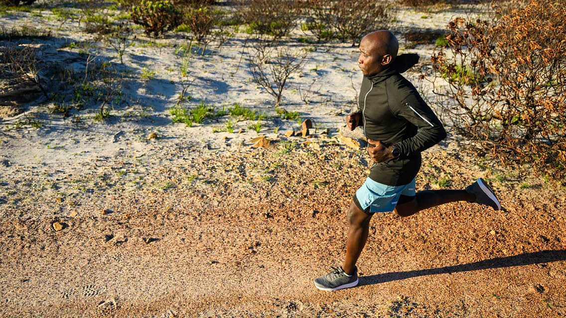 a man runs in the desert with a jacket