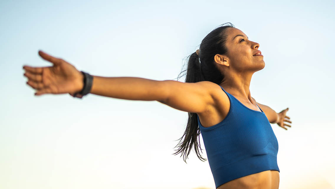 a woman stands with her arms open wide