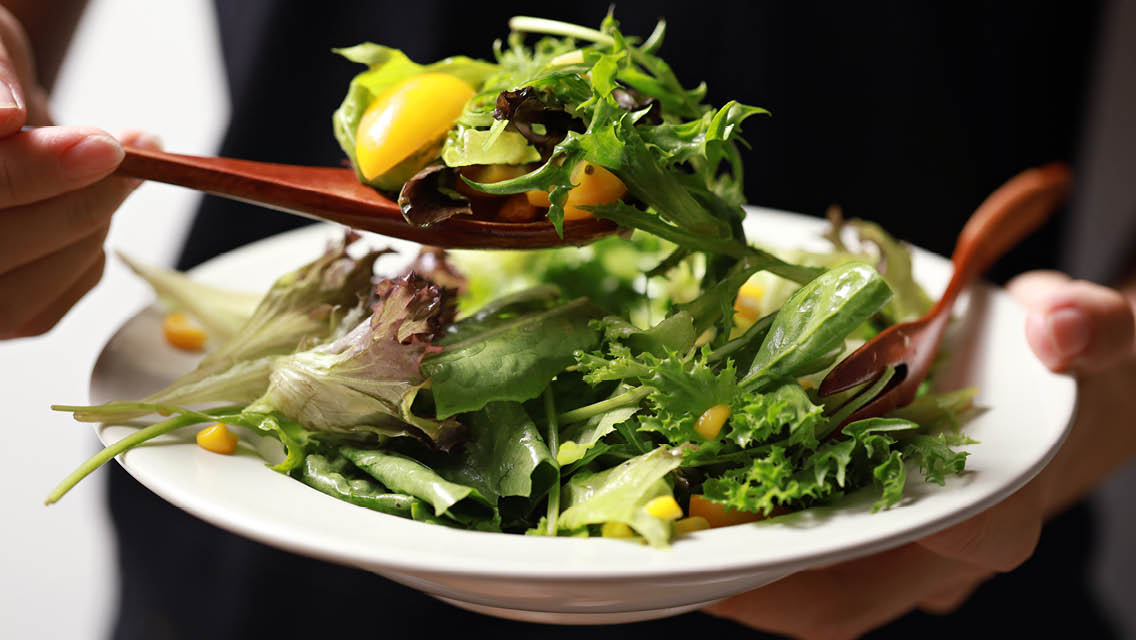a person eats a green salad