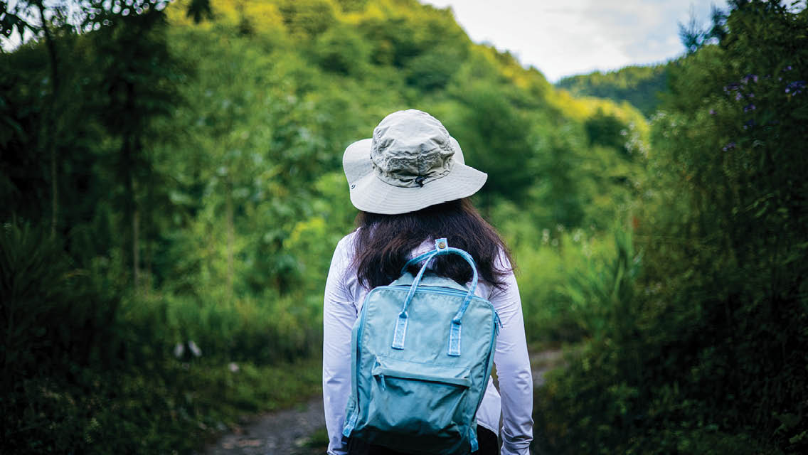 a woman walks on a nature trail